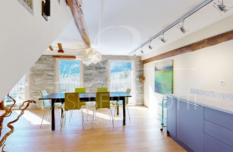 Heller Essbereich mit Natursteinwand und Holzbalken