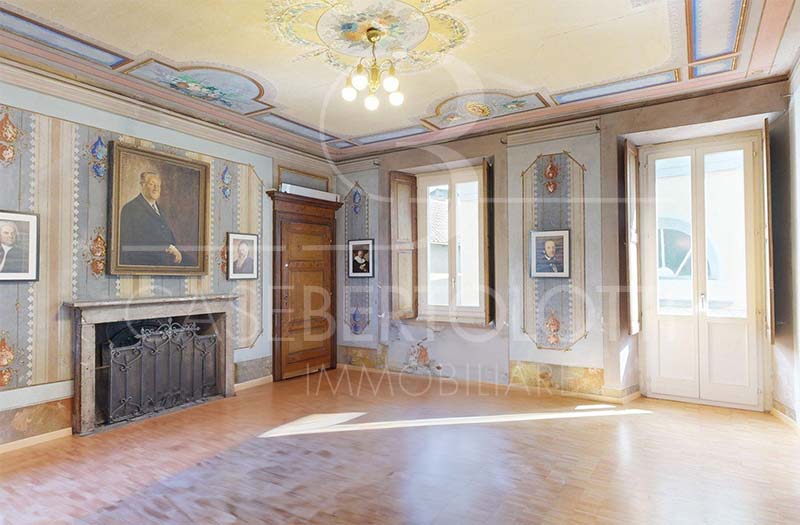 Eleganter historischer Salon mit Kamin und hohen Fenstern